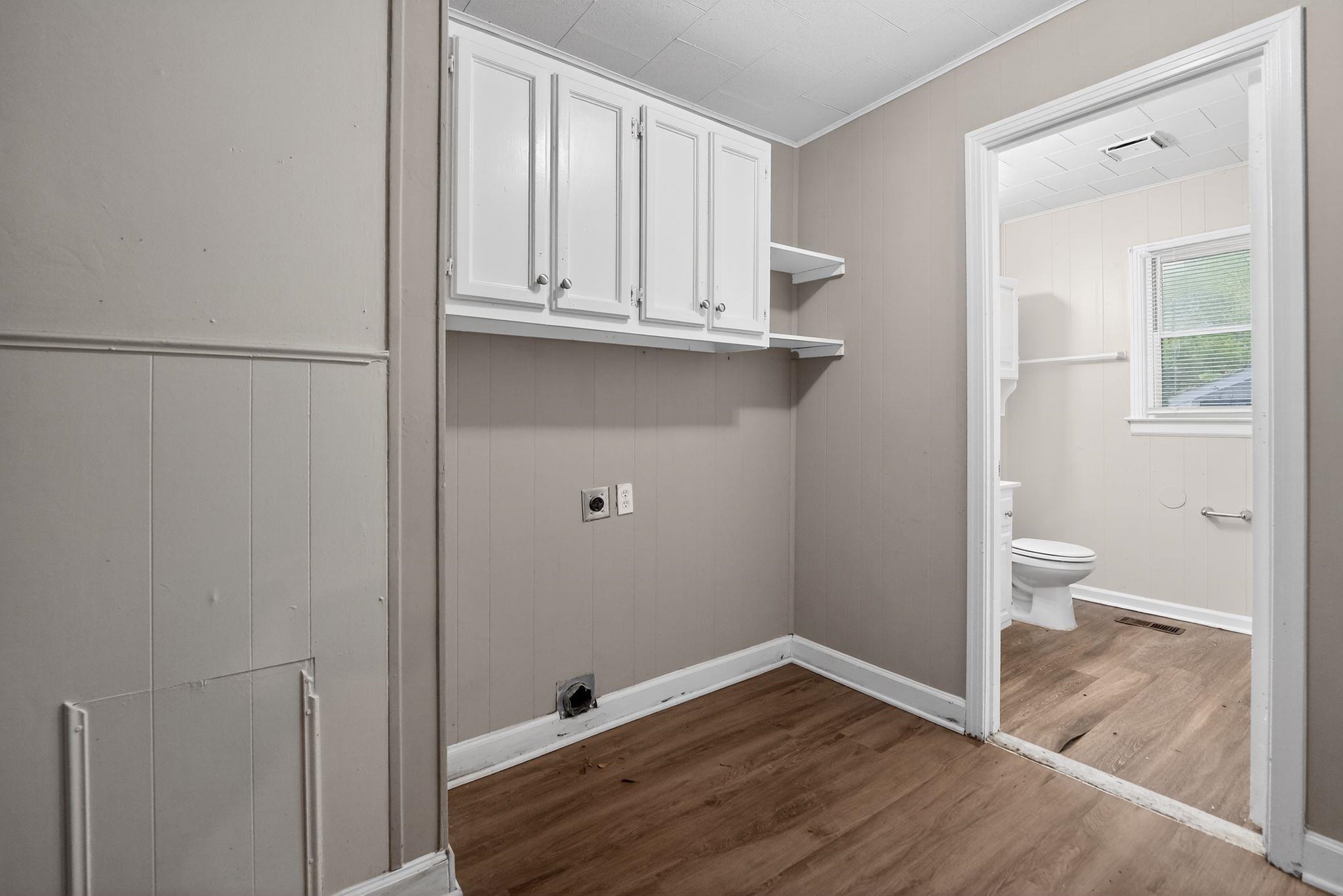 4067 Grantham Road Memphis, TN 38109 - Photo 34 of 34 Laundry area with electric dryer hookup, dark wood finished floors, and cabinet space