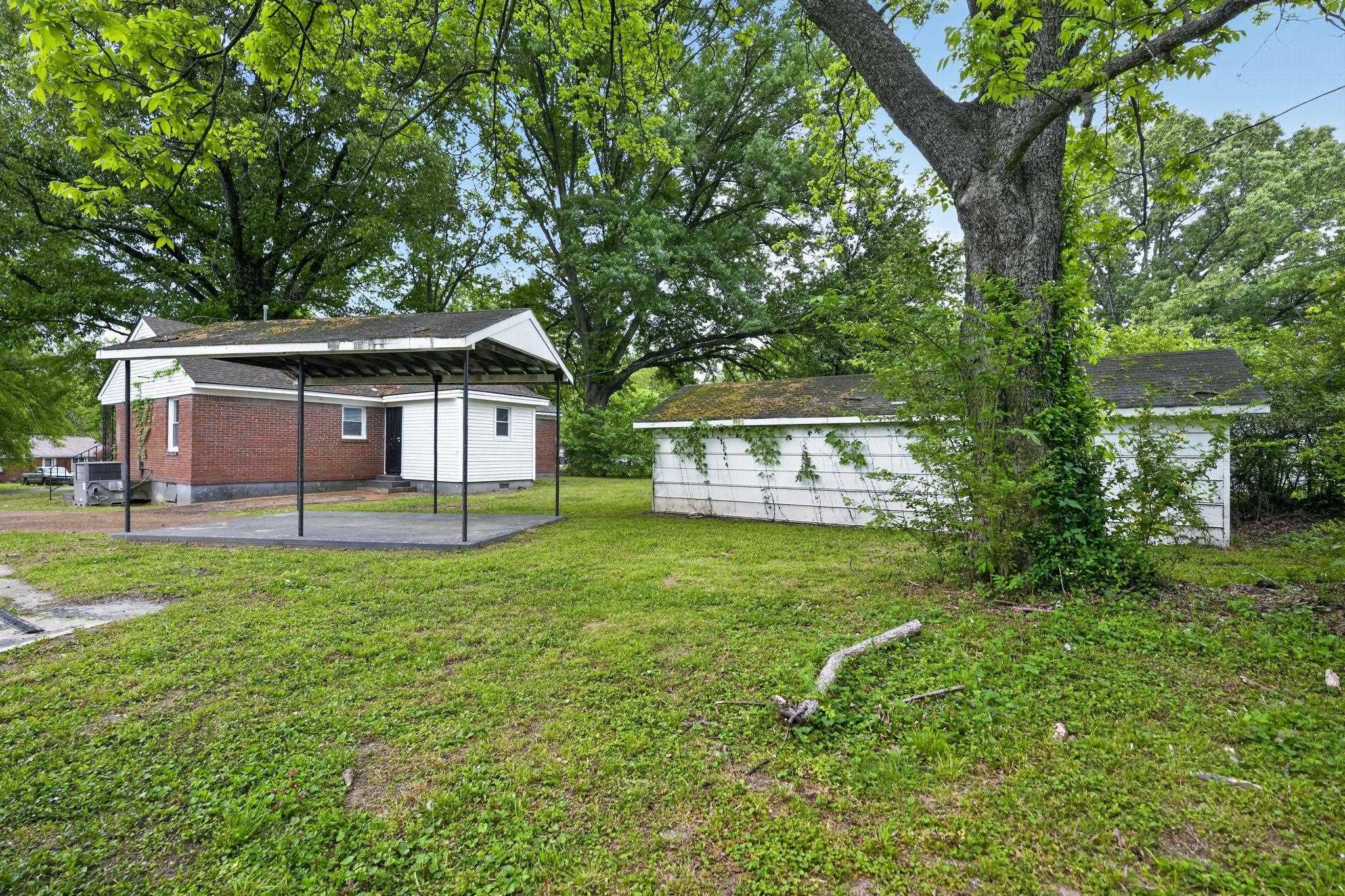 4067 Grantham Road Memphis, TN 38109 - Photo 5 of 34 View of grassy yard featuring a carport and a storage shed
