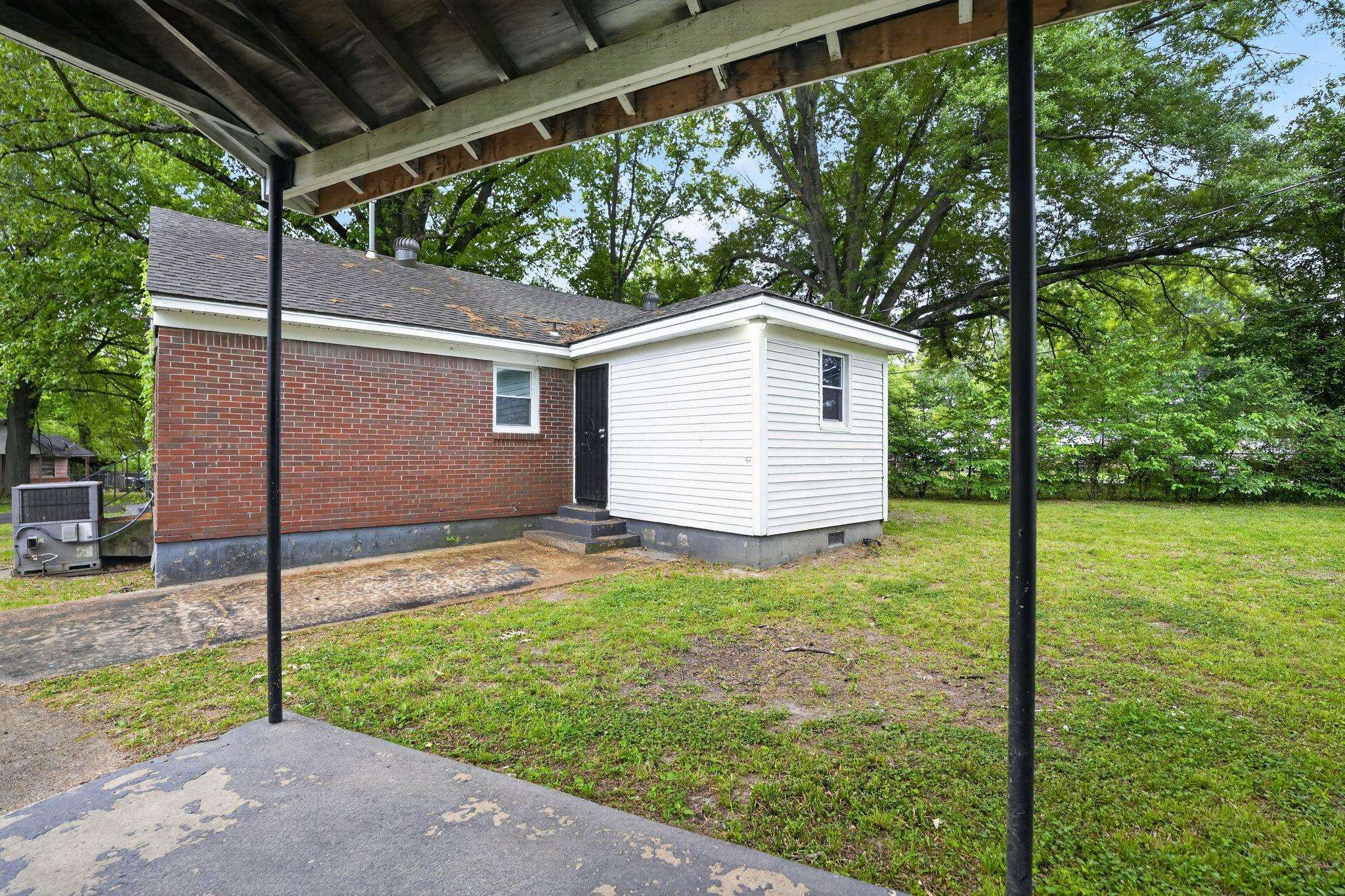4067 Grantham Road Memphis, TN 38109 - Photo 7 of 34 Rear view of house with a yard, brick siding, entry steps, and crawl space