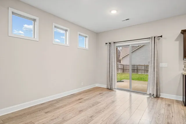 an empty room with wooden floor and a window