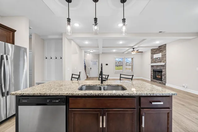 a kitchen with granite countertop kitchen island a sink appliances and a counter space