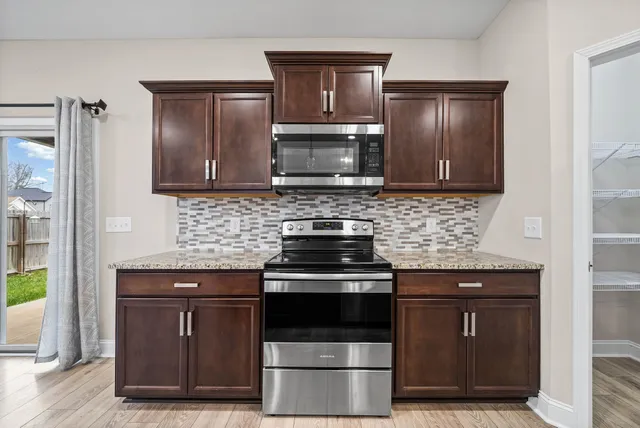 a kitchen with granite countertop a stove and a refrigerator