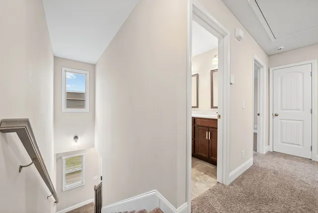 a view of a hallway with white walls and entryway