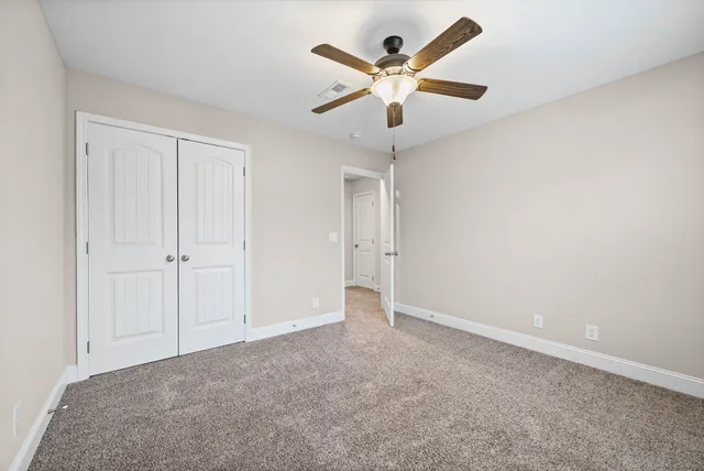 an empty room with a ceiling fan and a chandelier fan