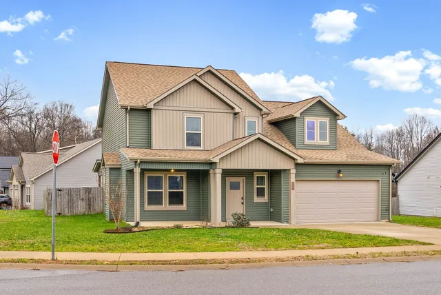 a front view of a house with a garden and yard