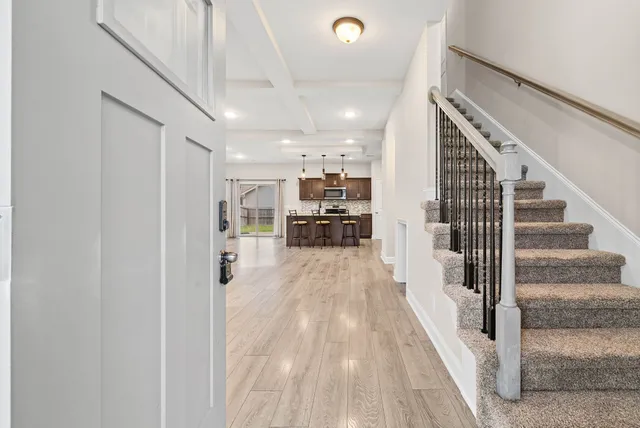 a view of front door with entryway and wooden floor