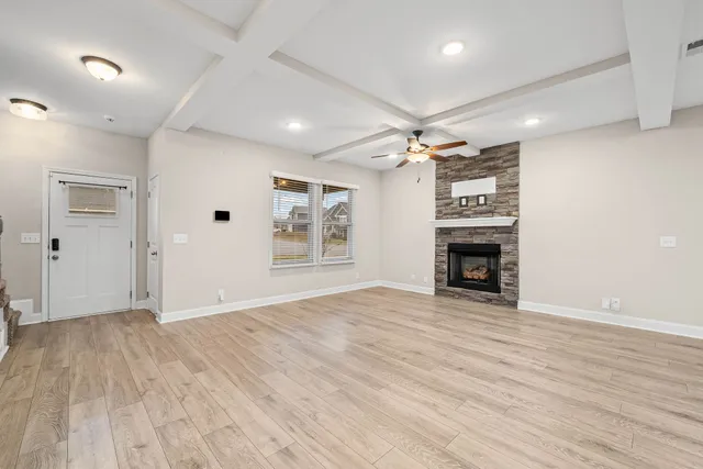 a view of empty room with wooden floor and fireplace