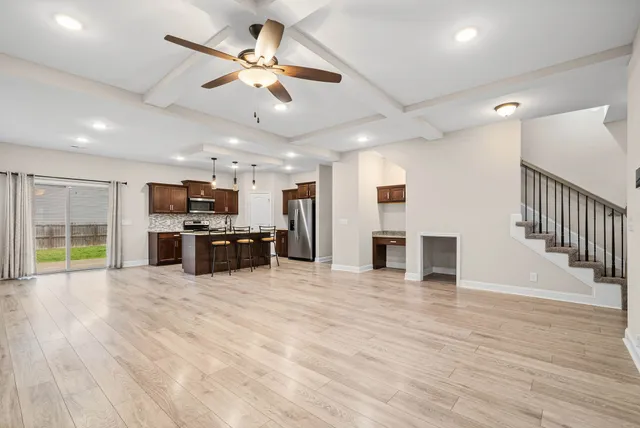 a view of an empty room with wooden floor and windows