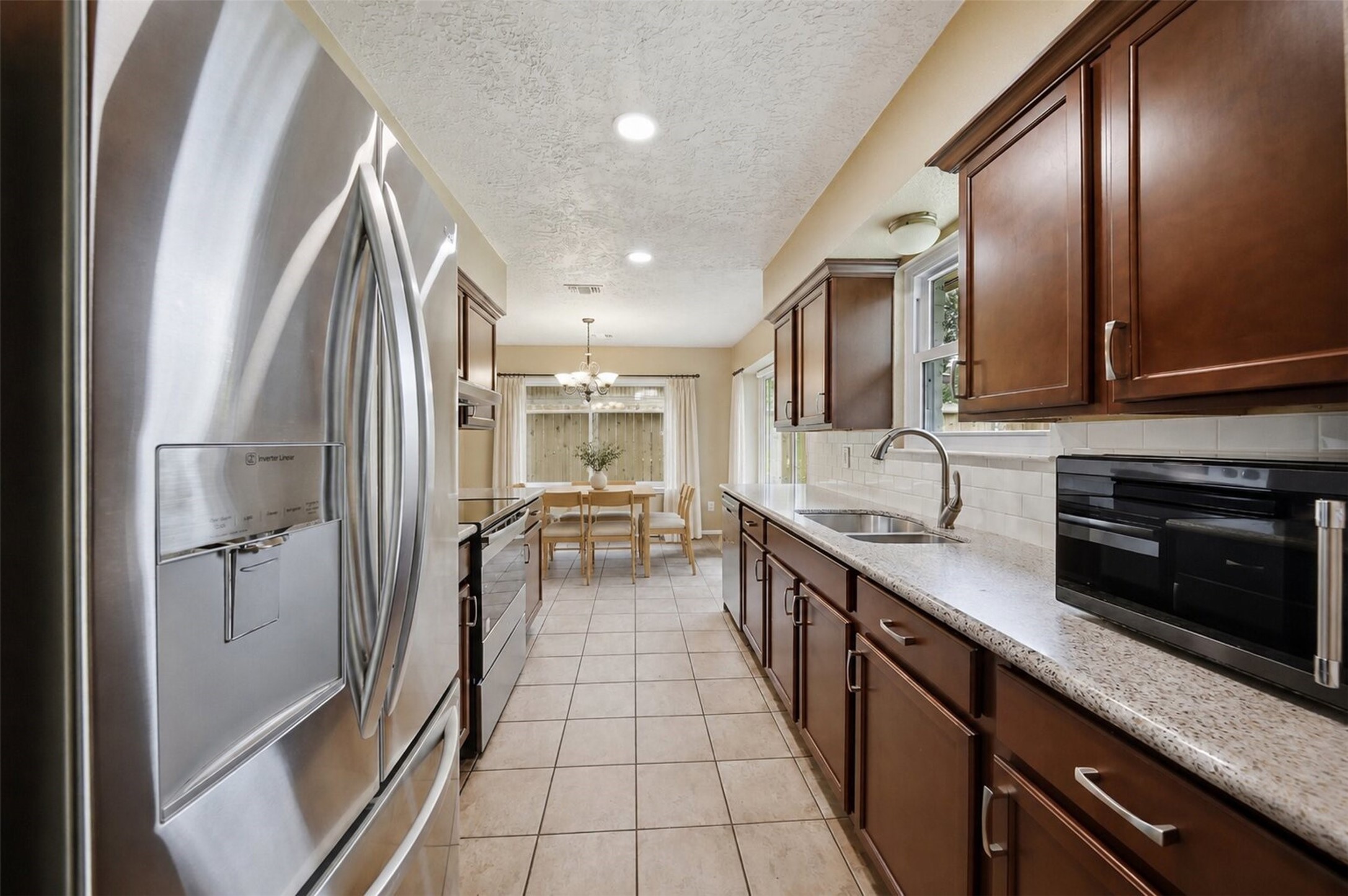 9418 Kilrenny Drive Spring, TX 77379 - Photo 9 of 47 a kitchen with stainless steel appliances granite countertop a refrigerator and a sink