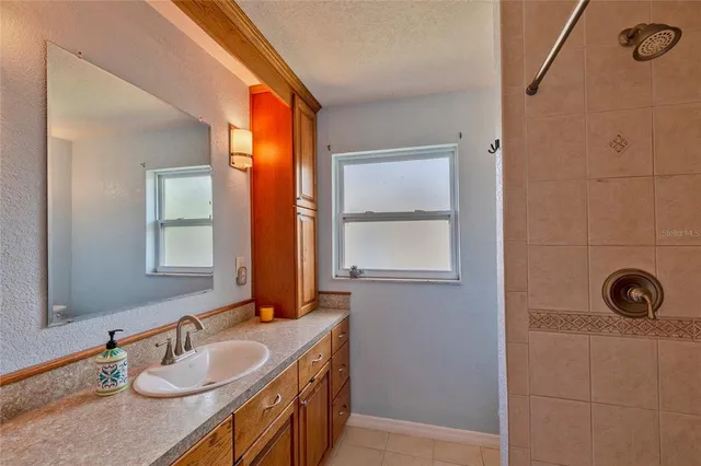 a bathroom with a sink a mirror and a window