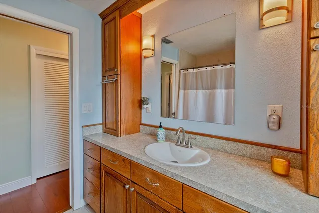 a bathroom with a granite countertop sink and a mirror