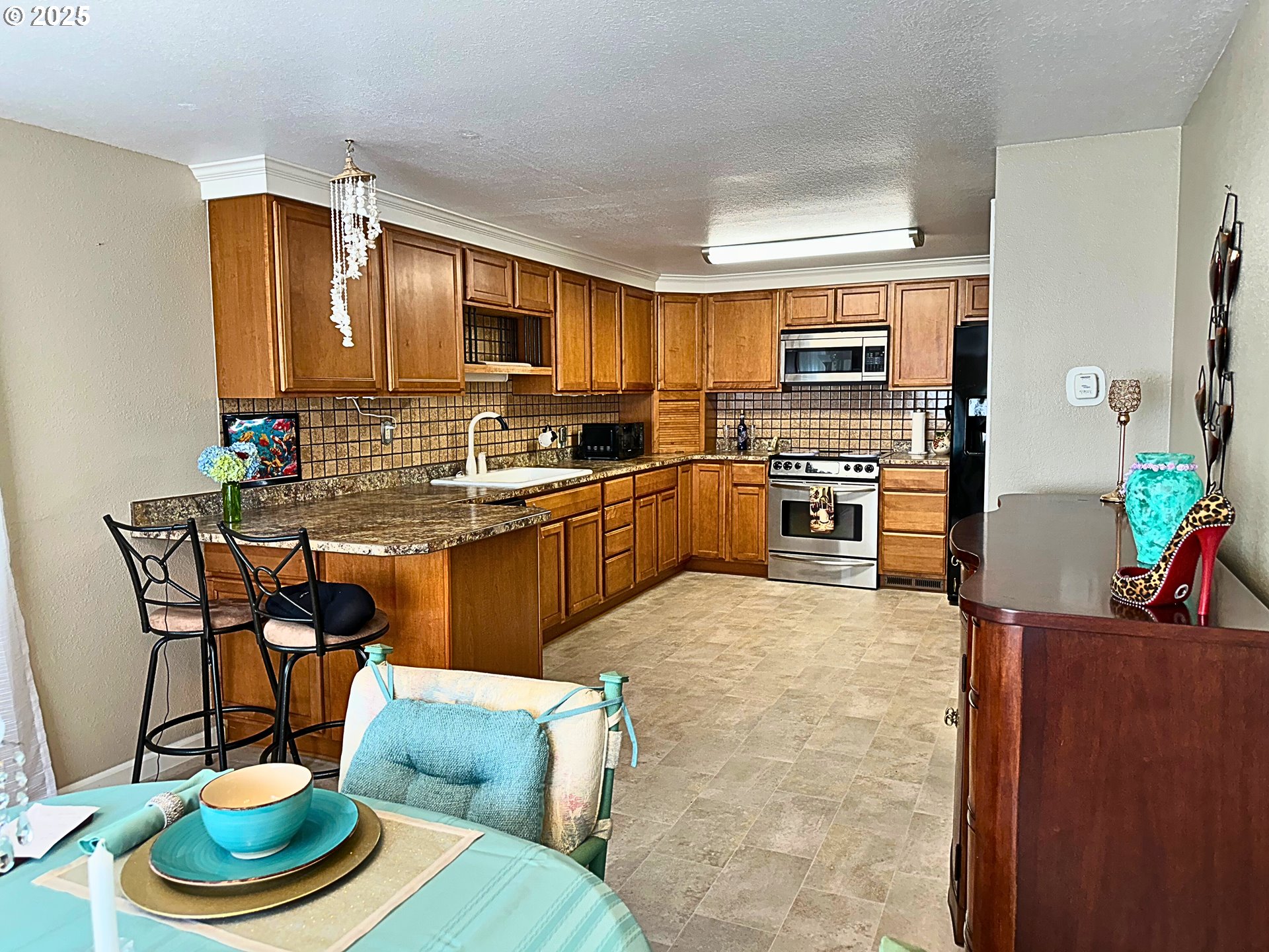 1600 Rhododendron Drive, Unit 218 Florence, OR 97439 - Photo 7 of 40 a kitchen with a stove a sink and a dining table