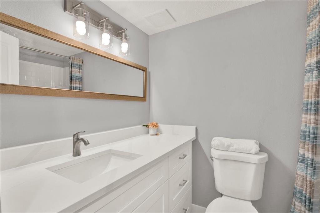 337 Rex Place, Unit A Madeira Beach, FL 33708 - Photo 23 of 48 a bathroom with a toilet sink and mirror