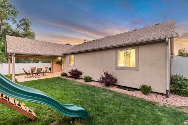 356 North 230 West Payson, UT 84651 - Photo 42 of 45 Expansive green lawn with a covered patio area, stucco exterior, and mature landscaping