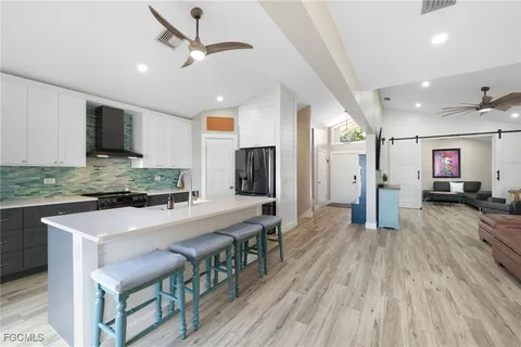 a large kitchen with stainless steel appliances granite countertop a lot of counter space and a wooden floor