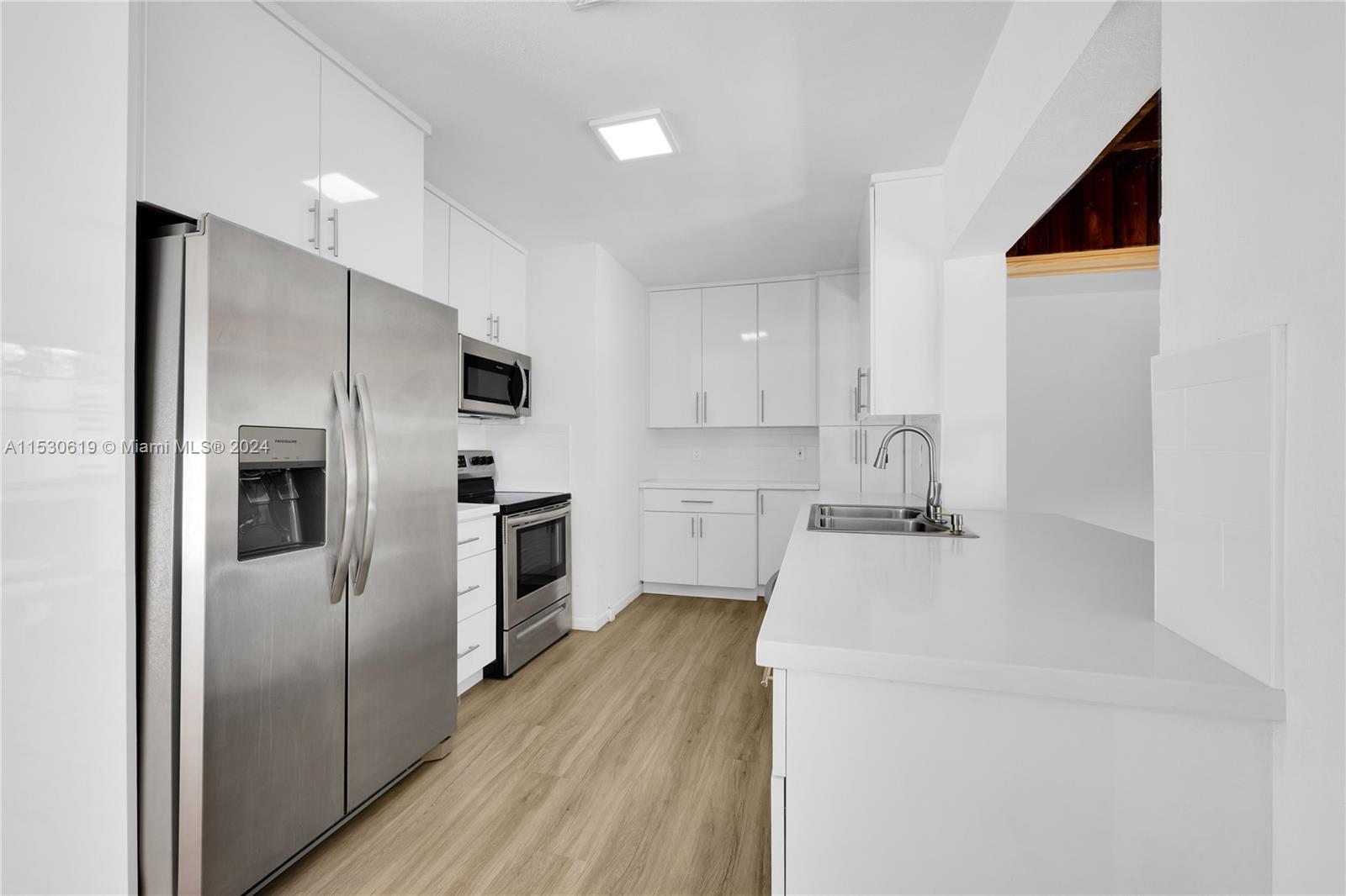 6520 Southwest 46th Street Miami, FL 33155 - Photo 17 of 40 a kitchen with a refrigerator sink and wooden floor