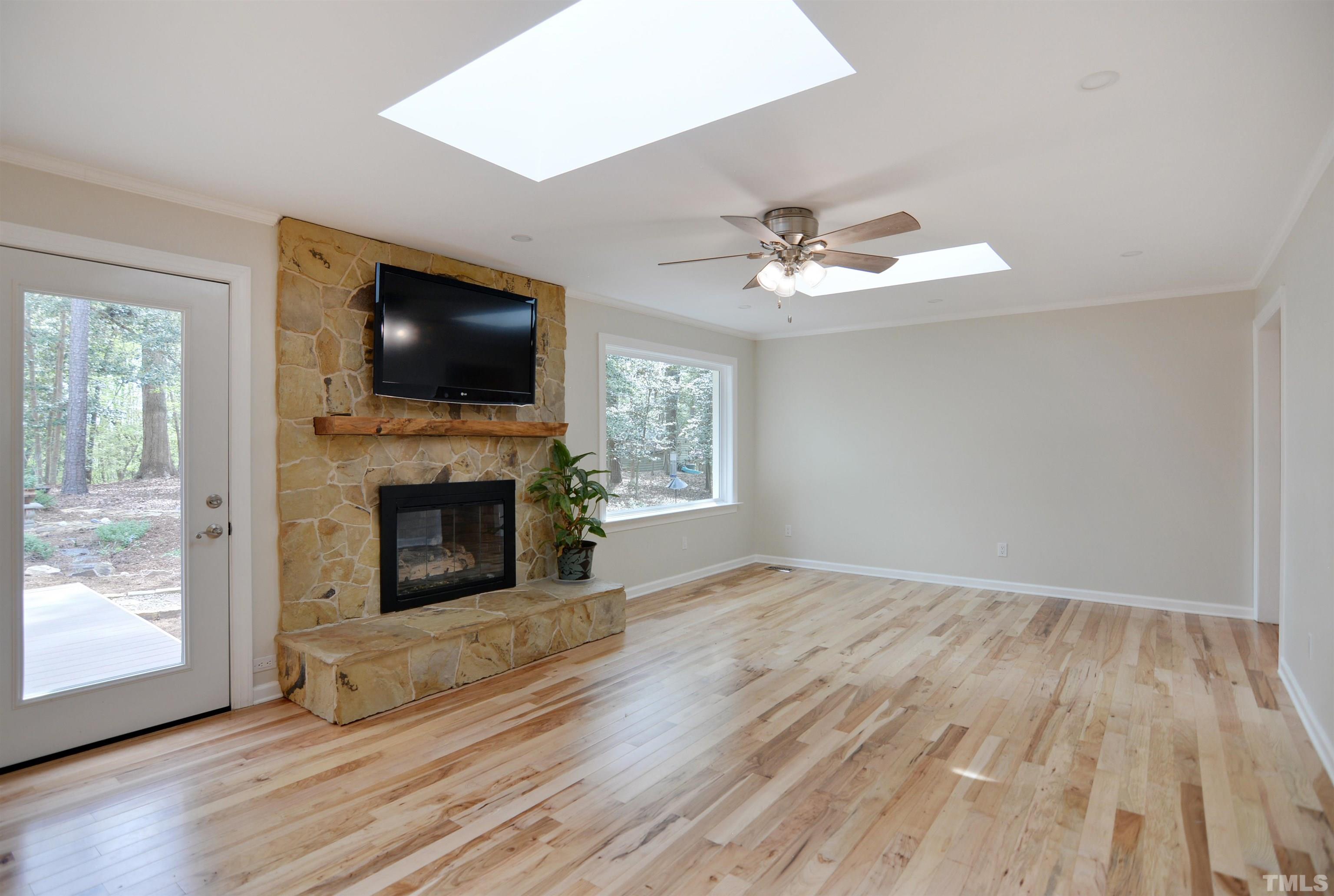 6120 Riverside Drive Wake Forest, NC 27587 - Photo 5 of 26 a view of a livingroom with a fireplace a ceiling fan and windows