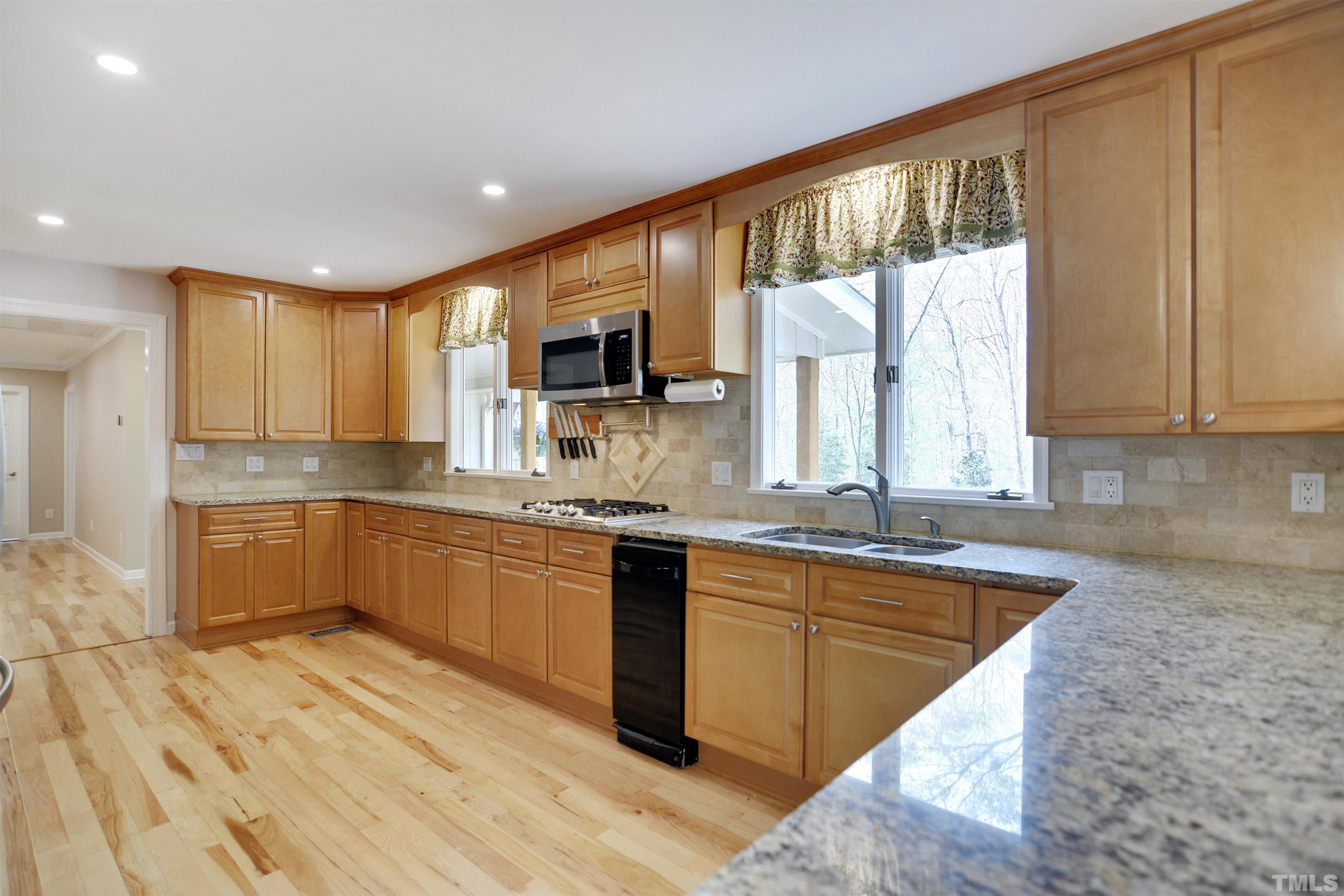 6120 Riverside Drive Wake Forest, NC 27587 - Photo 10 of 26 a large kitchen with stainless steel appliances granite countertop a sink a stove cabinets and wooden floor