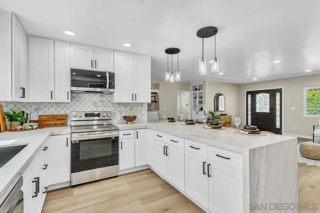 13725 Adrian Street Poway, CA 92064 - Photo 11 of 52 a kitchen with kitchen island granite countertop a sink a stove and cabinets