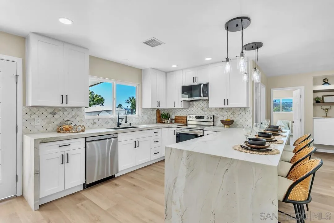 13725 Adrian Street Poway, CA 92064 - Photo 12 of 52 a kitchen with white cabinets and appliances