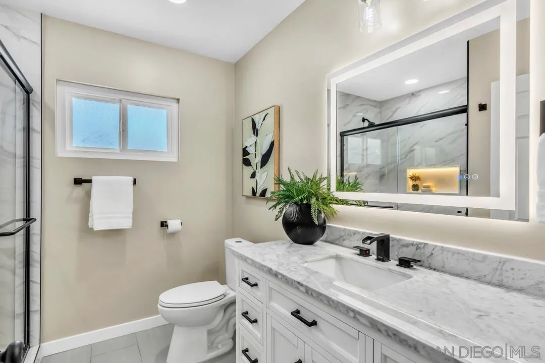 13725 Adrian Street Poway, CA 92064 - Photo 26 of 52 a bathroom with a granite countertop sink toilet and mirror