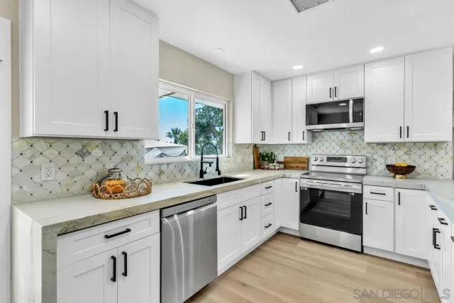 a kitchen with stainless steel appliances granite countertop a sink and stove top oven
