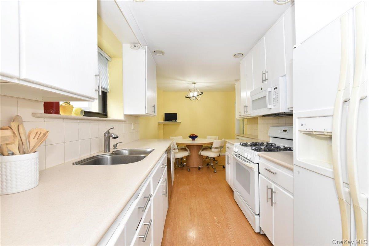 40 Stoner Avenue, Unit 1I Great Neck, NY 11021 - Photo 16 of 22 a kitchen with stainless steel appliances a sink stove and cabinets