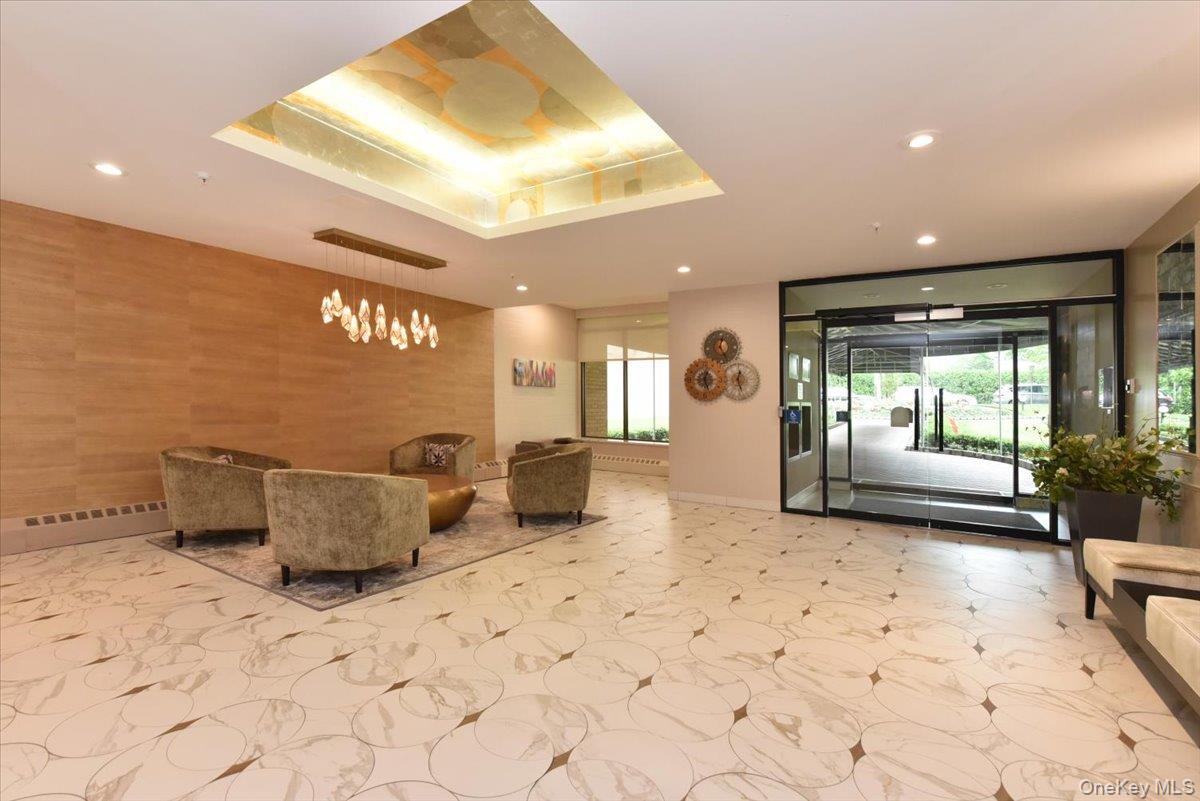 40 Stoner Avenue, Unit 1I Great Neck, NY 11021 - Photo 6 of 22 a lobby with a couch and a potted plant