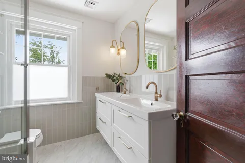 a bathroom with a double vanity sink mirror and shower
