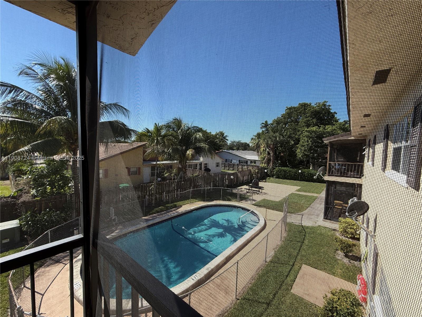 8900 West Sample Road, Unit 204 Coral Springs, FL 33065 - Photo 18 of 21 a view of a balcony with floor to ceiling windows and wooden fence