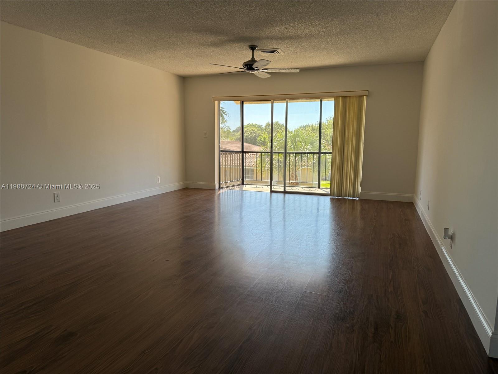 8900 West Sample Road, Unit 204 Coral Springs, FL 33065 - Photo 6 of 21 a view of an empty room with wooden floor and a window