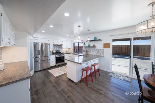 224 Richard Court Ridgecrest, CA 93555 - Photo 11 of 49 a living room with stainless steel appliances granite countertop furniture wooden floor and a kitchen view