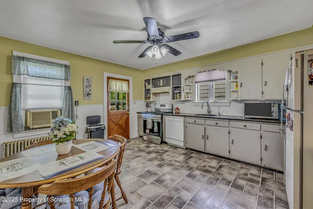 a kitchen with a table chairs refrigerator and cabinets