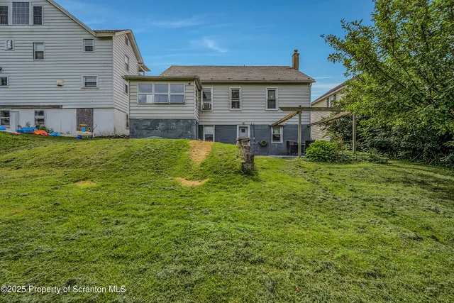 a view of a house with a big yard plants and large trees