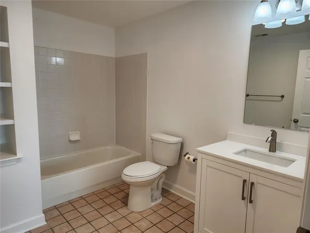 a bathroom with a toilet a sink a mirror and bathtub