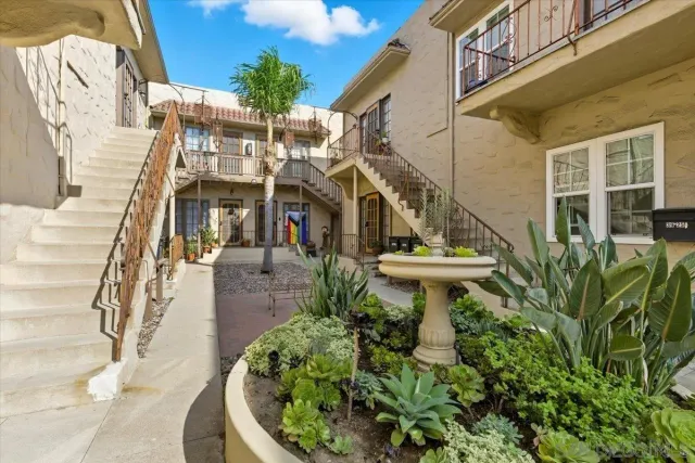 a view of a house with a fountain plants and large tree