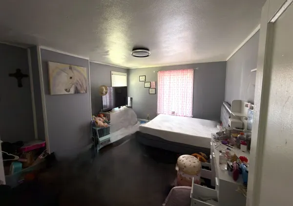 a bedroom with furniture and a large window