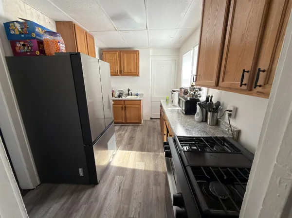 a kitchen with stainless steel appliances a refrigerator a sink a stove and white cabinets