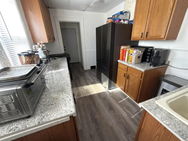 a kitchen with sink refrigerator and wooden floor