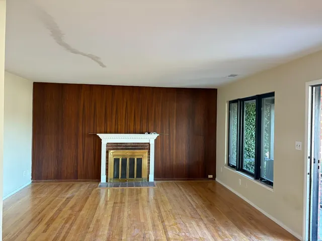 an empty room with windows and a fireplace