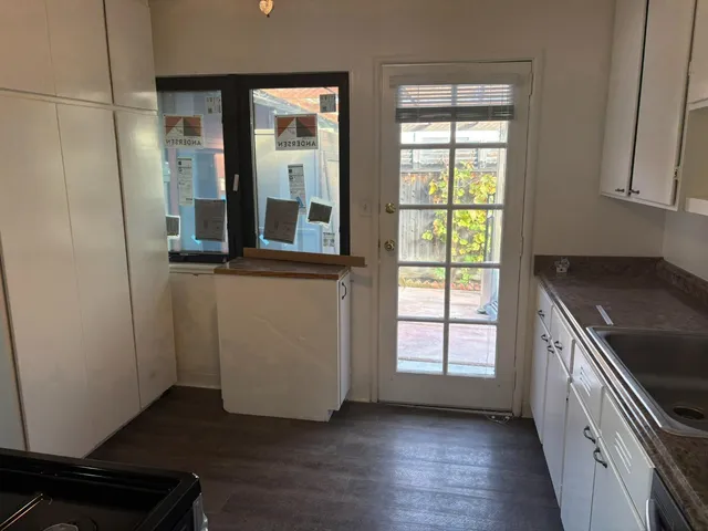 an entryway with wooden floor and cabinets