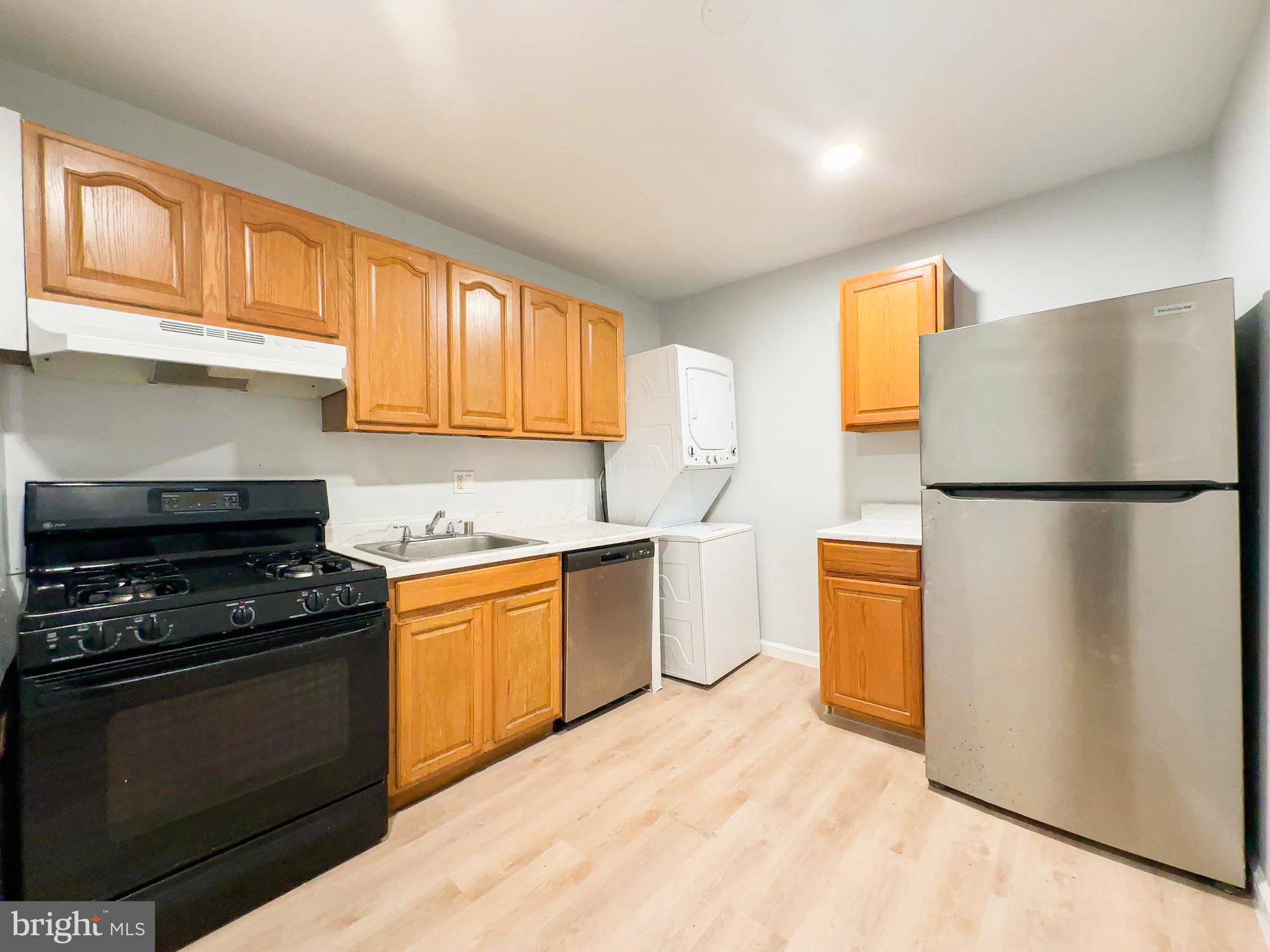 8671 Greenbelt Road, Unit 101 Greenbelt, MD 20770 - Photo 3 of 14 a kitchen with granite countertop a refrigerator stove top oven and sink