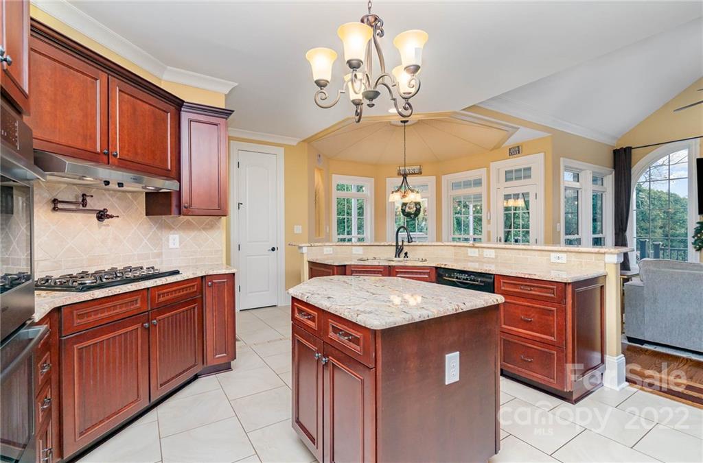3210 Lake Shore Road South Denver, NC 28037 - Photo 18 of 44 a kitchen with stainless steel appliances granite countertop wooden cabinets a stove a sink a dining table and chairs