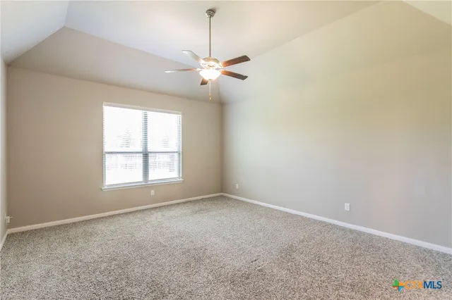an empty room with windows and fan