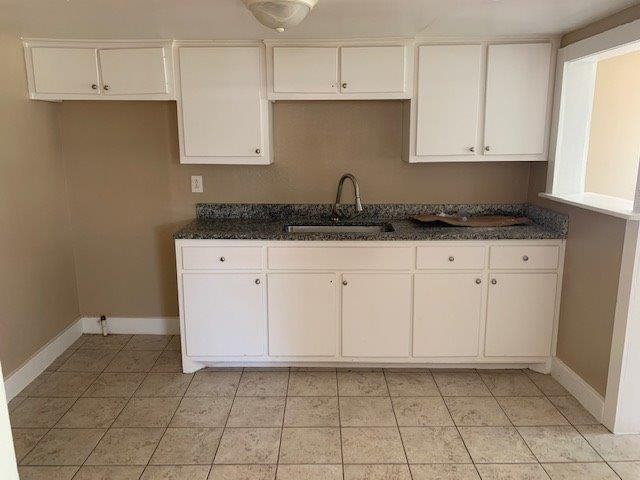3014 Duke Street Lubbock, TX 79415 - Photo 4 of 10 a kitchen with granite countertop white cabinets and sink