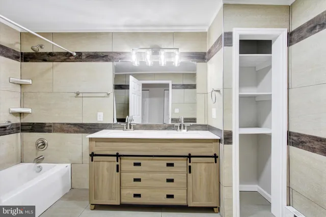 a bathroom with a double vanity sink mirror and bathtub