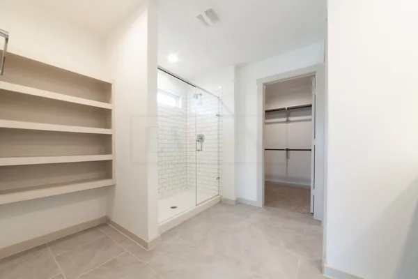 a view of walk in closet with empty racks