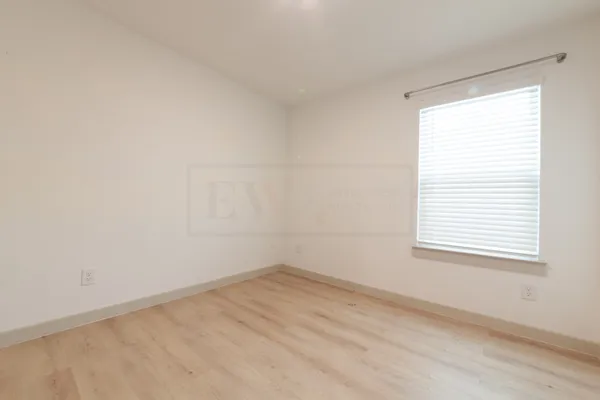 an empty room with windows and closet
