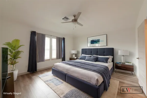 a bedroom with a large bed and a potted plant