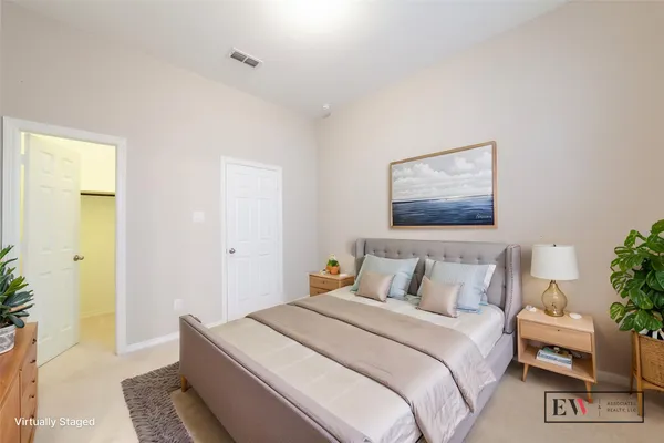 a bedroom with a bed and a painting on the wall